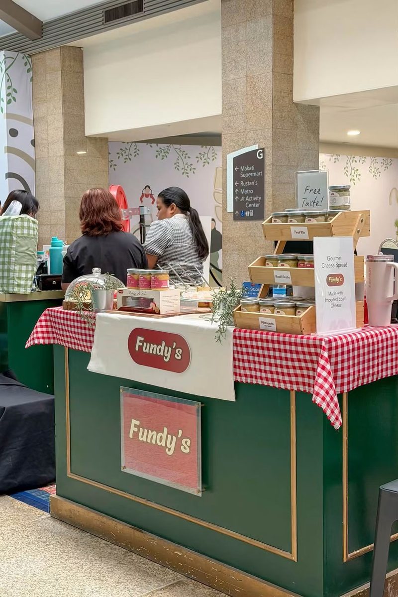 Fundy's bazaar booth with a red gingham tablecloth, green counter and a free taste sign