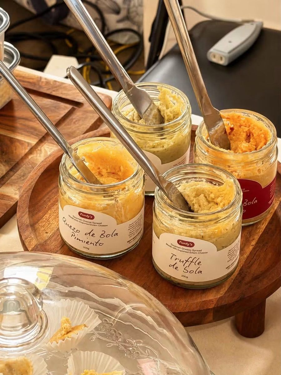 Four open jars of Fundy's Spread on a wooden tray with spreaders